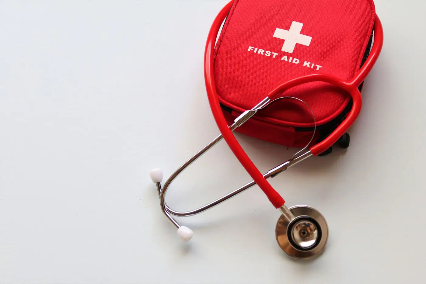 Kit de primeiros socorros e estetoscópio representando cobertura médica de viagem