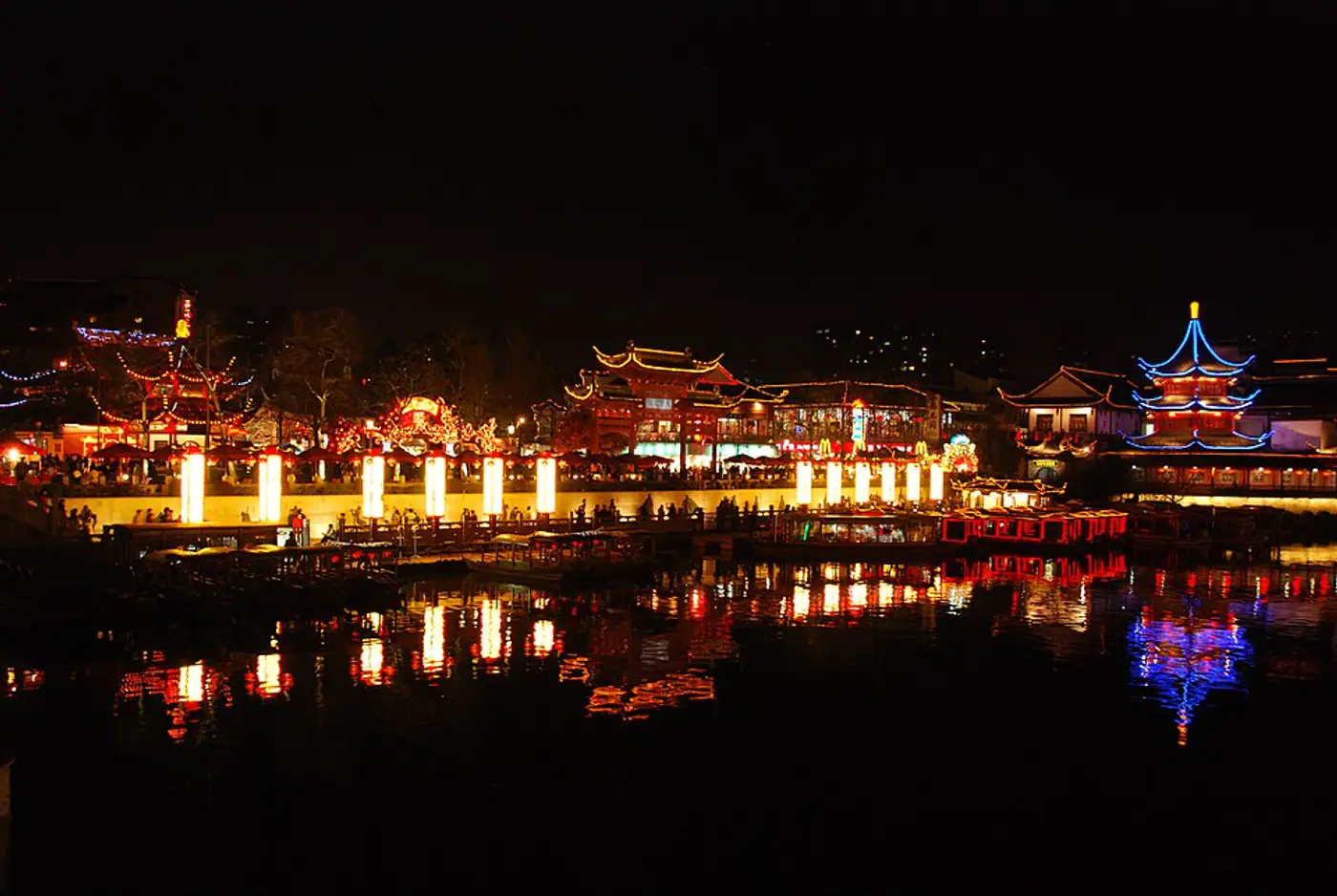 Templo de Confúcio e edifícios iluminados refletidos no Rio Qinhuai à noite