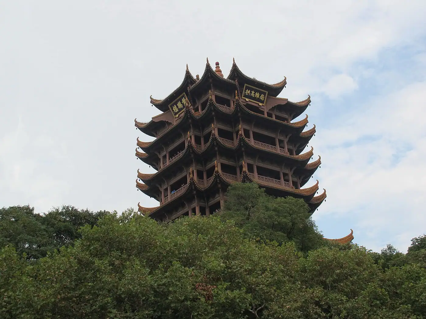 Exterior da Torre do Guindaste Amarelo acima das árvores em Wuhan