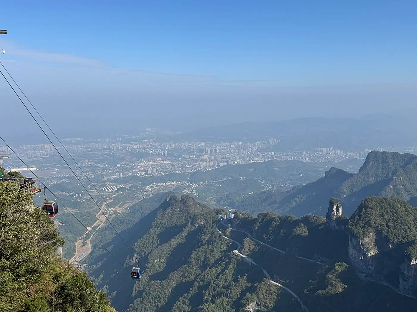 Teleférico da Montanha Tianmen acima dos vales e da cidade de Zhangjiajie